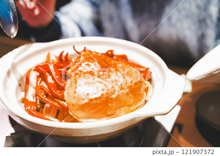 カニ鍋の蓋を開ける若い女性【撮影協力・海鮮居酒屋　魚魯こ】 121907372