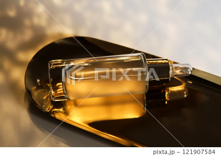 A bottle of cosmetic serum with a pipette on a festive golden background. A bottle of cosmetic serum with a pipette on a festive golden background. 121907584