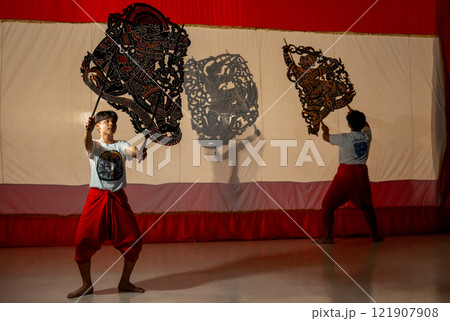 Asian young men show or perform grand shadow play together to present Thai culture and traditional performance for tourist and the other people and conservation good culture. 121907908