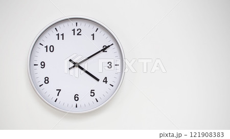 Minimalist White Clock with Silver Frame Striking 16.10/04.10 on White Background. Perfect for Time Management and Corporate Campaigns 121908383