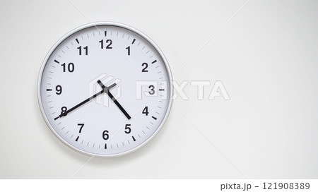 Minimalist White Clock with Silver Frame Striking 16.40/04.40 on White Background. Perfect for Time Management and Corporate Campaigns Minimalist White Clock with Silver Frame Striking 16.40/04.40 on White Background. Perfect for Time Management and Corporate Campaigns 121908389