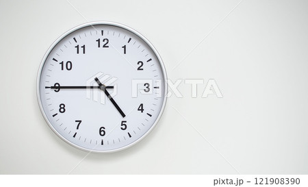 Minimalist White Clock with Silver Frame Striking 16.45/04.45 on White Background. Perfect for Time Management and Corporate Campaigns Minimalist White Clock with Silver Frame Striking 16.45/04.45 on White Background. Perfect for Time Management and Corporate Campaigns 121908390