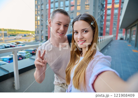 Selfie portrait of happy friends guy and girl college students looking at camera 121908409