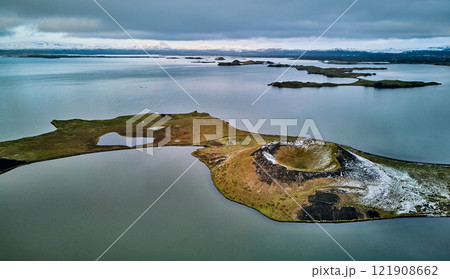 ミーヴァトン湖周辺の火山と静かな湖面 121908662