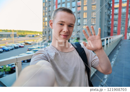 Selfie portrait of young happy teenage guy, outdoor 121908703