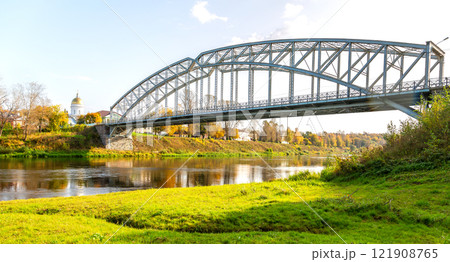 View on the steel arch bridge across the Msta river in summer. Built in 1905. Borovichi, Russia 121908765