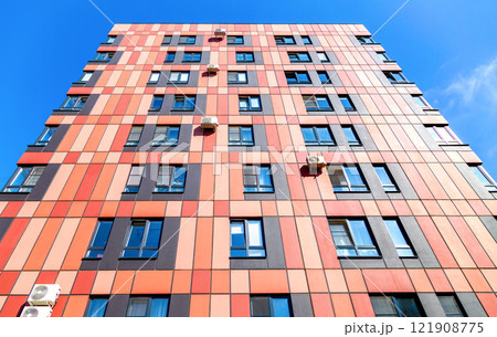 Facade of new bright colorful modern residential building against a sky 121908775
