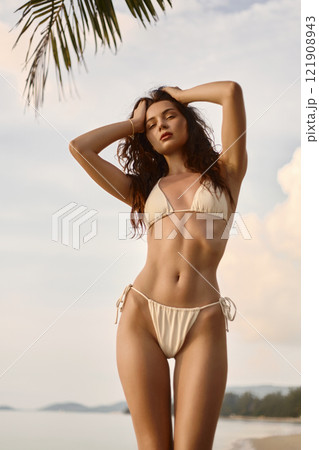 Beautiful body woman on the beach. Sexy girl in Bikini at sunset Beautiful body woman on the beach. Sexy girl in Bikini at sunset 121908943