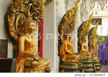 A group of Buddha statues in various postures with a serpent covering the top. Decorated around the chapel at Wat Naga Prok Temple. Located at Bangkok capital city in Thailand. 121908967
