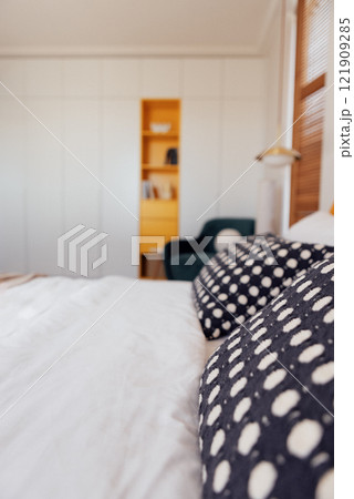 A modern bedroom with a comfortable bed and a bright yellow headboard A modern bedroom with a comfortable bed and a bright yellow headboard 121909285