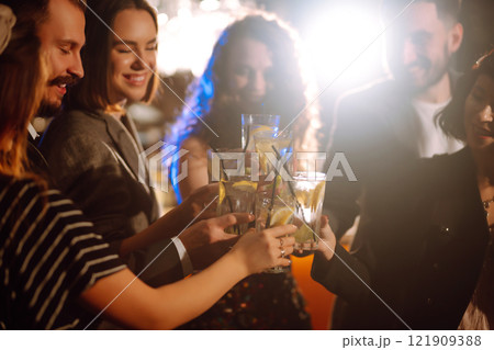 Cheering and drinking cocktails. Group of friends partying in nightclub, toasting drinks cocktails. Cheering and drinking cocktails. Group of friends partying in nightclub, toasting drinks cocktails. 121909388
