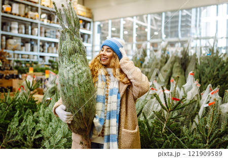 A woman in a blue hat chooses to celebrate Christmas at a fair. Holiday concept. Lifestyle. A woman in a blue hat chooses to celebrate Christmas at a fair. Holiday concept. Lifestyle. 121909589