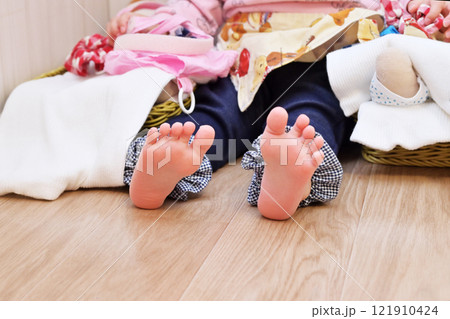 子供とフローリング　小さな足　素足　裸足　清潔な床　床に座る乳幼児　イメージ素材 121910424
