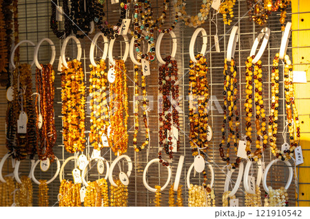 Amber stones market, polished orange gemstones closeup, natural Baltic amber gems jewelry store Amber stones market, polished orange gemstones closeup, natural Baltic amber gems jewelry store 121910542