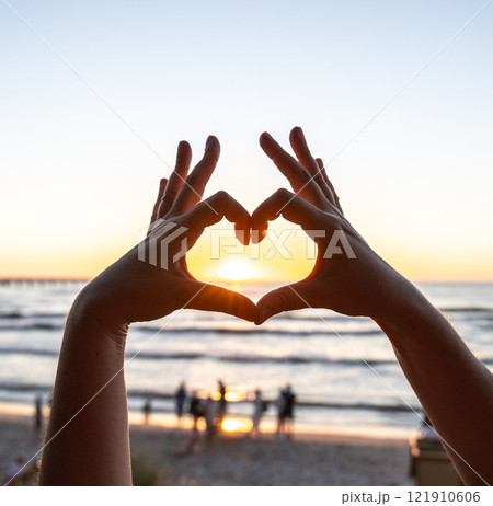 Hands gesture, love you sign at beach sunset, romantic emoji and happiness at ocean holiday Hands gesture, love you sign at beach sunset, romantic emoji and happiness at ocean holiday 121910606