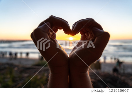 Hands gesture, love you sign at beach sunset, romantic emoji and happiness at ocean holiday Hands gesture, love you sign at beach sunset, romantic emoji and happiness at ocean holiday 121910607