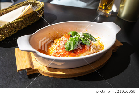 Lasagna portion, oven baked lasagne, pasta layers with cheese, minced meat, tomato in sunny summer day 121910959
