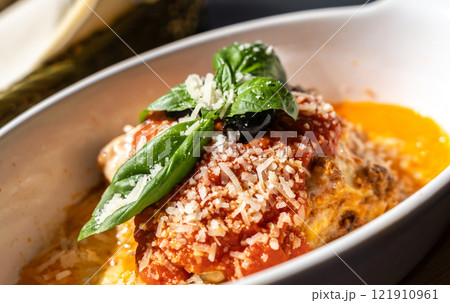 Lasagna portion, oven baked lasagne, pasta layers with cheese, minced meat, tomato in sunny summer day Lasagna portion, oven baked lasagne, pasta layers with cheese, minced meat, tomato in sunny summer day 121910961