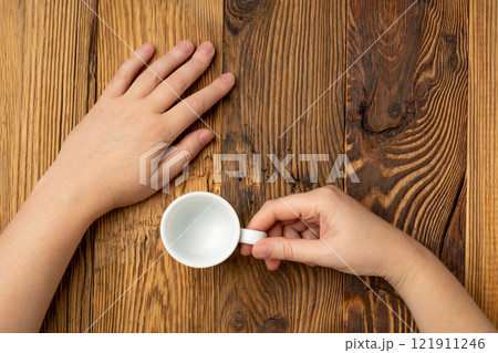 Hand Holds Cup, Empty White Cup in Hands, Coffee Mug, Teacup Mockup, Cup in Arms on Wooden Table Hand Holds Cup, Empty White Cup in Hands, Coffee Mug, Teacup Mockup, Cup in Arms on Wooden Table 121911246