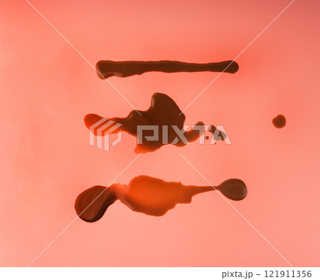 Spilled chocolate milk, hot chocolate puddle, liquid stain, coffee splatter, brown latte with on pink Spilled chocolate milk, hot chocolate puddle, liquid stain, coffee splatter, brown latte with on pink 121911356