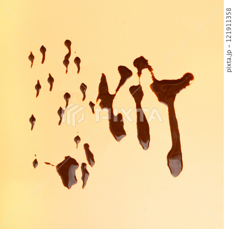 Spilled chocolate milk, hot chocolate puddle, liquid stain, coffee splatter, brown latte with on yellow Spilled chocolate milk, hot chocolate puddle, liquid stain, coffee splatter, brown latte with on yellow 121911358