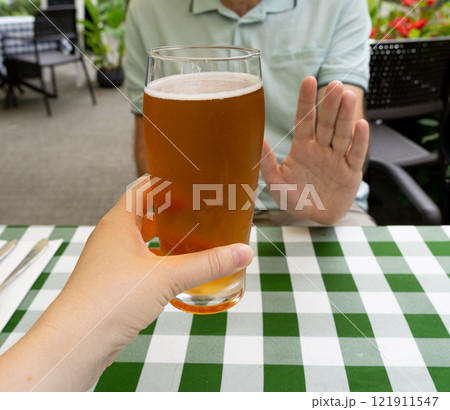 Reject a glass of beer, man refusing alcohol, stop drinking, sobriety concept, saying no to beer glass 121911547