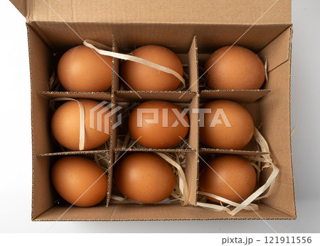 Open egg box with brown eggs. Fresh organic chicken eggs in carton pack container closeup Open egg box with brown eggs. Fresh organic chicken eggs in carton pack container closeup 121911556