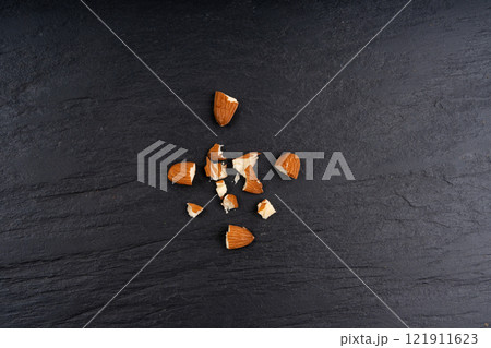 Crushed almonds, nut pieces, sliced scattered almond seeds and cut kernels collection on black background Crushed almonds, nut pieces, sliced scattered almond seeds and cut kernels collection on black background 121911623
