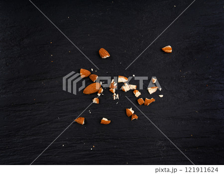 Crushed almonds, nut pieces, sliced scattered almond seeds and cut kernels collection on black background 121911624
