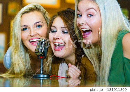 Women singing with microphone 121911809