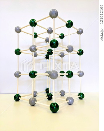 A model of a cube made of sticks and balls is on a table 121912169