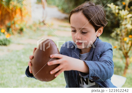 Little boy and Easter egg of ciocolate Little boy and Easter egg of ciocolate 121912242