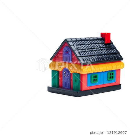 Colorful toy house made of plastic bricks placed on a green base for childrens playtime activities 121912697
