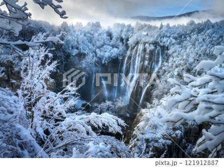 Aerial drone view of amazing waterfall and snowy forest in winter Aerial drone view of amazing waterfall and snowy forest in winter 121912887