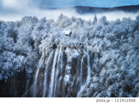 Aerial drone view of amazing waterfall and snowy forest in winter Aerial drone view of amazing waterfall and snowy forest in winter 121912888