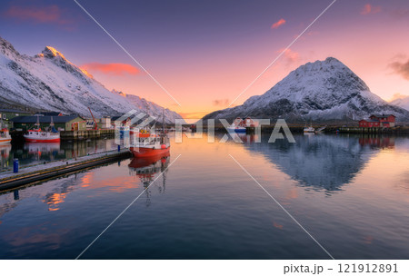 Red fishing boats on the sea, snowy mountains at colorful sunset Red fishing boats on the sea, snowy mountains at colorful sunset 121912891