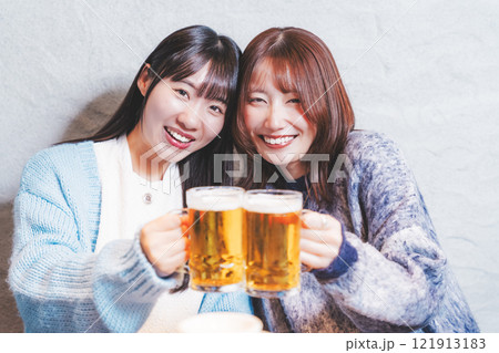 カニ鍋を前に乾杯をする若い女性二人【撮影協力・海鮮居酒屋 魚魯こ】 カニ鍋を前に乾杯をする若い女性二人【撮影協力・海鮮居酒屋 魚魯こ】 121913183