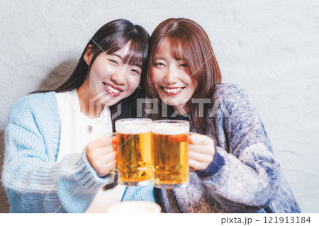 カニ鍋を前に乾杯をする若い女性二人【撮影協力・海鮮居酒屋　魚魯こ】 121913184