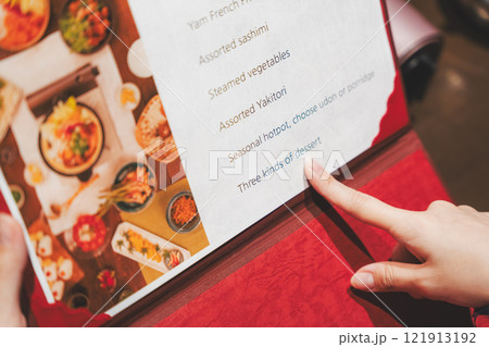 メニューを見て選ぶ女性客の手【撮影協力・海鮮居酒屋　魚魯こ】 121913192