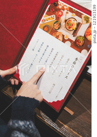メニューを見て選ぶ女性客の手【撮影協力・海鮮居酒屋　魚魯こ】 121913199