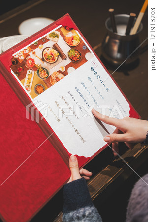 メニューを見て選ぶ女性客の手【撮影協力・海鮮居酒屋　魚魯こ】 121913203
