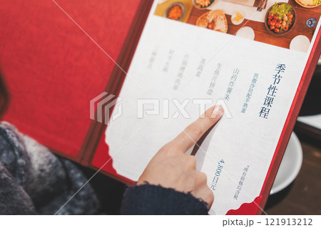 メニューを見て選ぶ女性客の手【撮影協力・海鮮居酒屋　魚魯こ】 121913212
