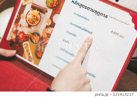 メニューを見て選ぶ女性客の手【撮影協力・海鮮居酒屋 魚魯こ】 メニューを見て選ぶ女性客の手【撮影協力・海鮮居酒屋 魚魯こ】 121913217