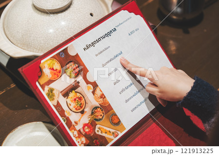 メニューを見て選ぶ女性客の手【撮影協力・海鮮居酒屋 魚魯こ】 メニューを見て選ぶ女性客の手【撮影協力・海鮮居酒屋 魚魯こ】 121913225