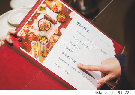 メニューを見て選ぶ女性客の手【撮影協力・海鮮居酒屋　魚魯こ】 121913229