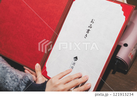 メニューを見て選ぶ女性客の手【撮影協力・海鮮居酒屋　魚魯こ】 121913234