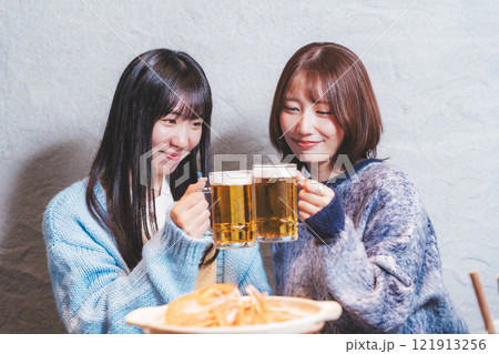 カニ鍋を前に乾杯をする若い女性二人【撮影協力・海鮮居酒屋　魚魯こ】 121913256
