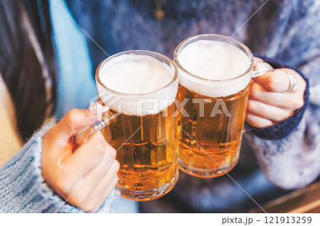 カニ鍋を前に乾杯をする若い女性二人【撮影協力・海鮮居酒屋　魚魯こ】 121913259