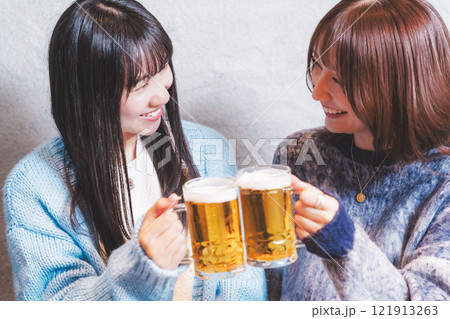 カニ鍋を前に乾杯をする若い女性二人【撮影協力・海鮮居酒屋　魚魯こ】 121913263