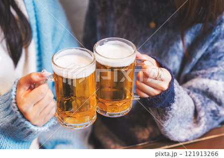 カニ鍋を前に乾杯をする若い女性二人【撮影協力・海鮮居酒屋 魚魯こ】 カニ鍋を前に乾杯をする若い女性二人【撮影協力・海鮮居酒屋 魚魯こ】 121913266